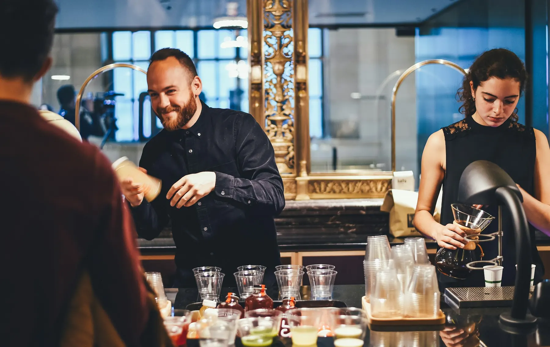 To bartendere blander drinks i baren til et arrangement.