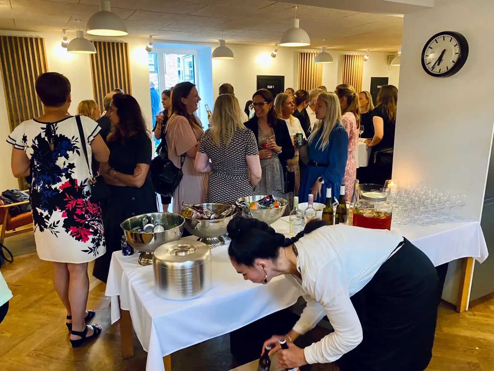 Gæster til en reception i et af Transformerstationens lokaler, mens en tjener gør buffeten klar.